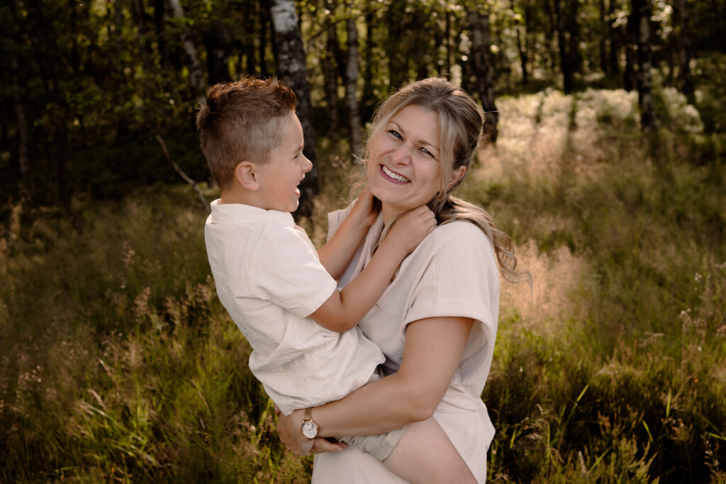Moeder tilt zoon op en hebben een onderonsje tijdens de gezinsshoot in de lente