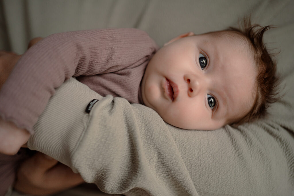 baby meisje op de arm van papa tijdens een newbornshoot thuis