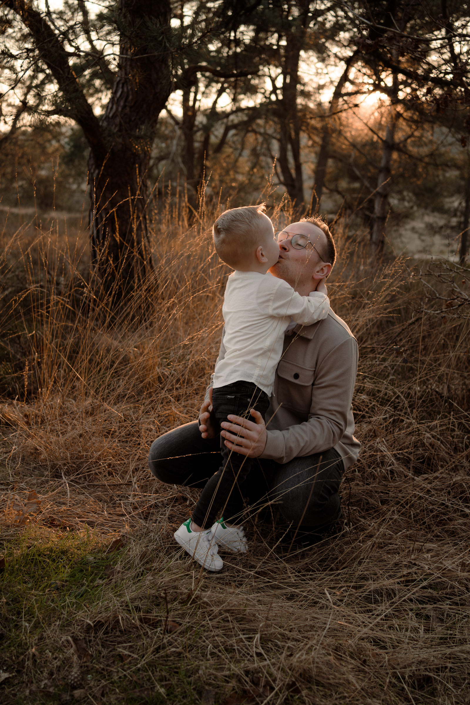 Vader en zoon tijdens een fotoshoot met zonsondergang