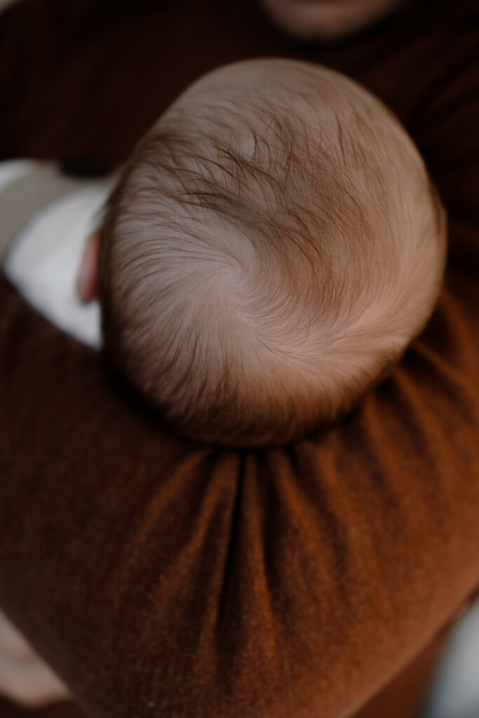 detail van het haardosje van de baby tijdens een newbornshoot thuis