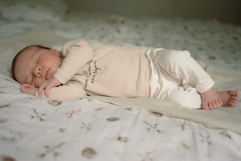 Baby ligt lekker te slapen op bed tijdens een newbornshoot aan huis Apeldoorn