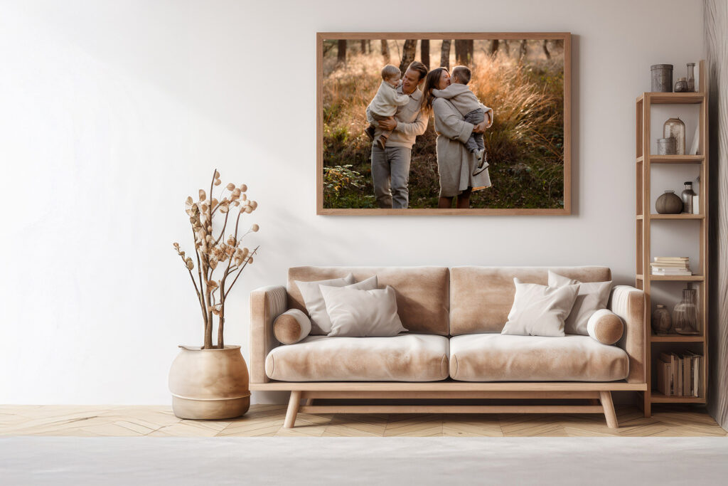 Mockup van een gezinsfoto als wanddecoratie boven een bank in een lichte woonkamer – voorbeeld van hoe je foto’s na een fotoshoot tastbaar en zichtbaar kunt maken.