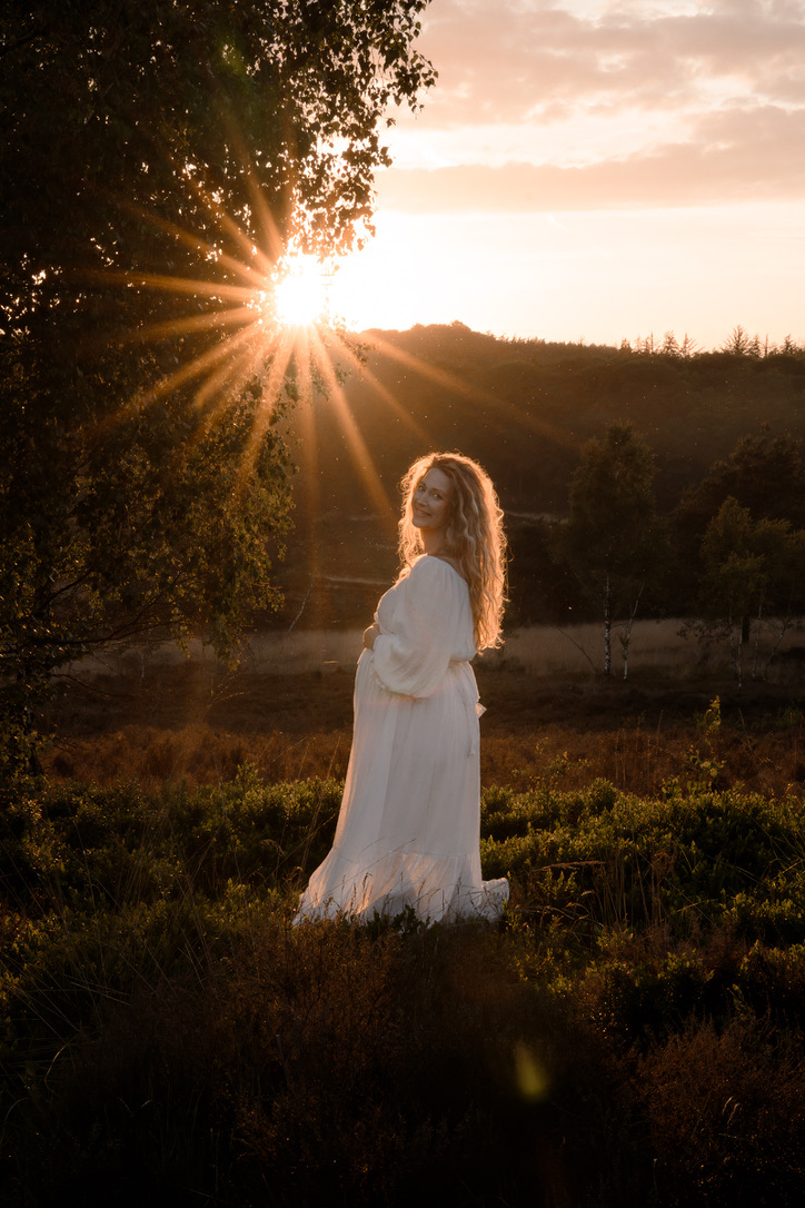 Zwangere dame gefotografeerd door Joenne Bokhorst Fotografie met prachtig tegenlicht tijdens een zwangerschapsshoot op de Veluwe