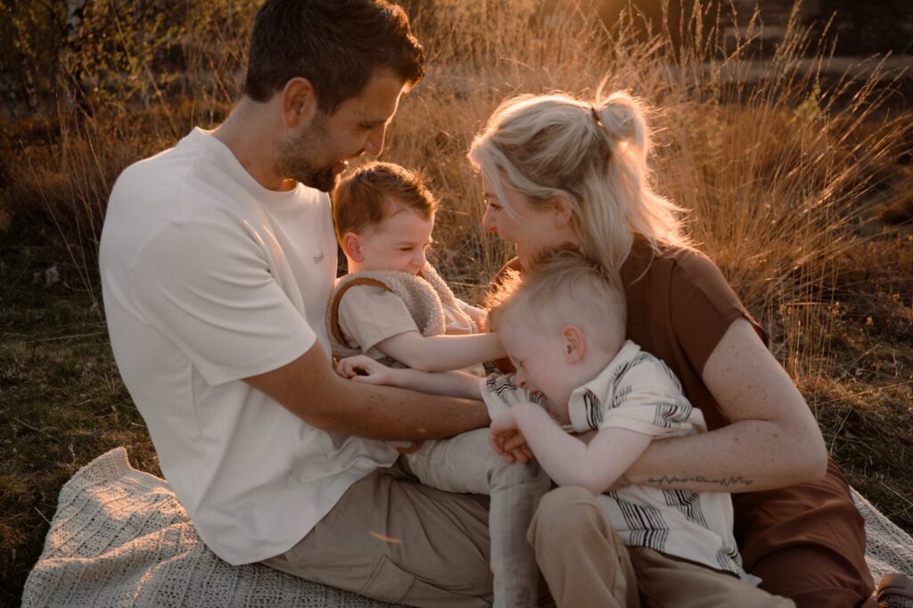Gezin zit in het bos tijdens een fotoshoot in Apeldoorn met Joenne Bokhorst Fotografie