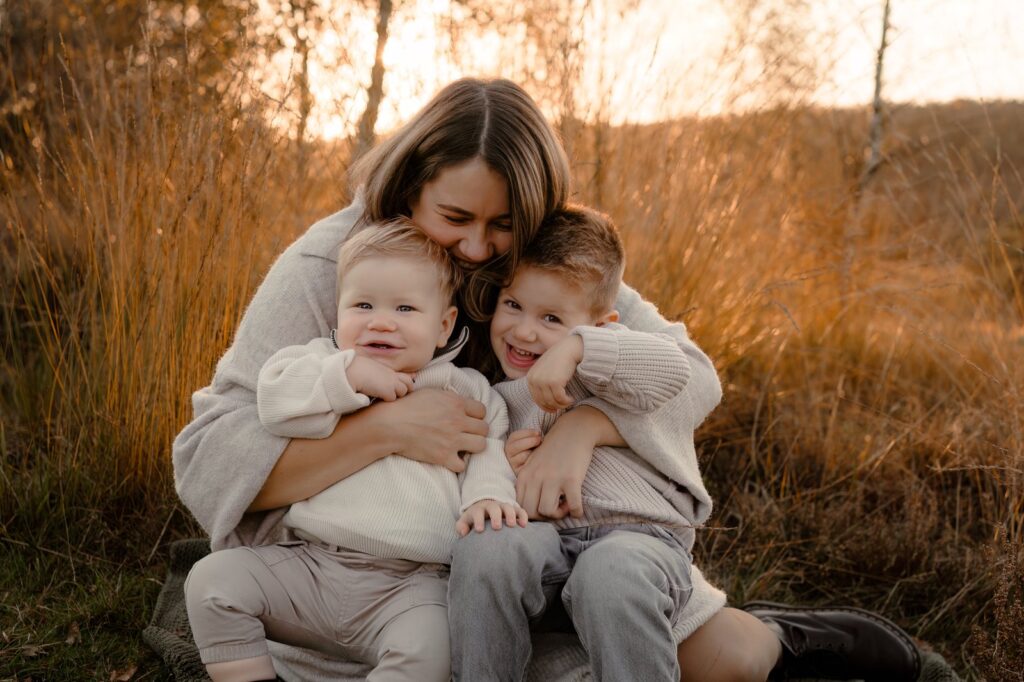Moeder zit met haar zoons in de natuur van Apeldoorn tijdens een fotoshoot