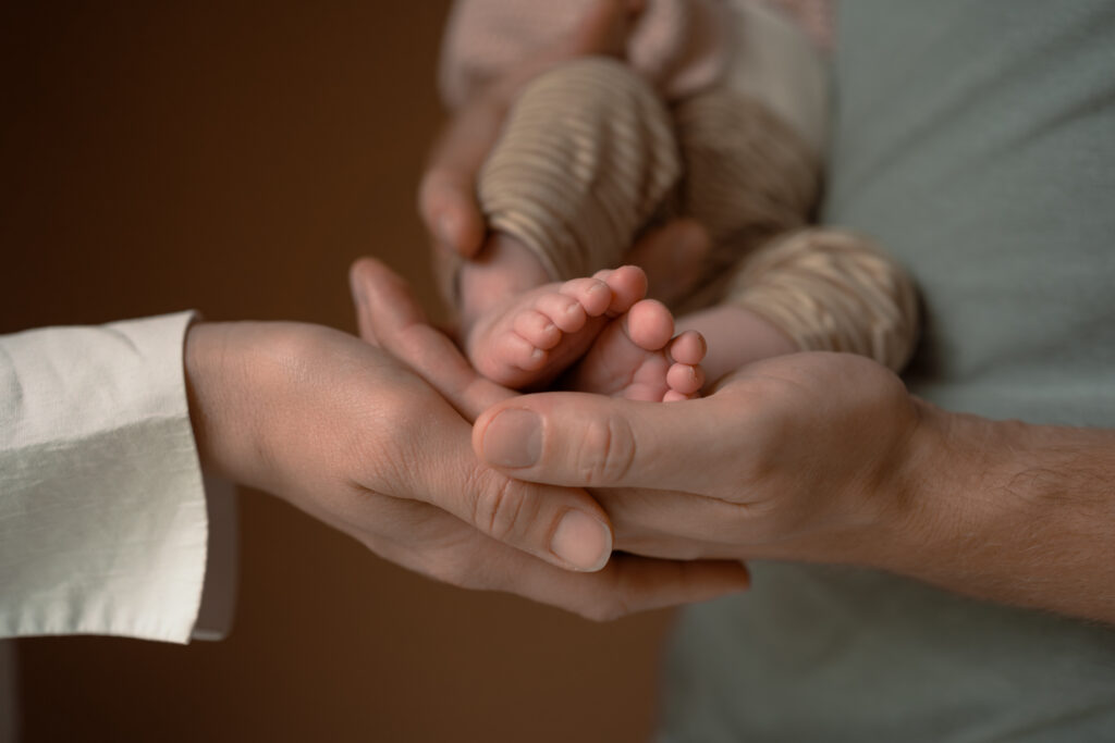 Detailfoto van de baby voetjes en de handen van vader en moeder tijdens een newbornshoot Apeldoorn door Joenne Bokhorst Fotografie