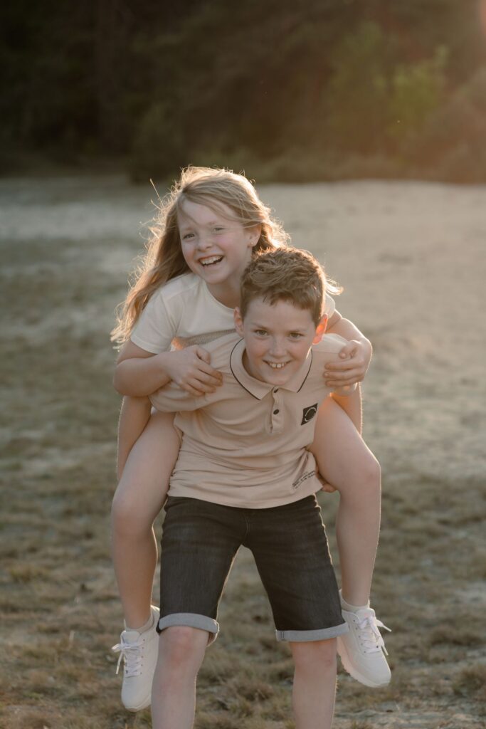 Broer en zus spelen met elkaar tijdens een gezinsshoot in de omgeving van Apeldoorn.
